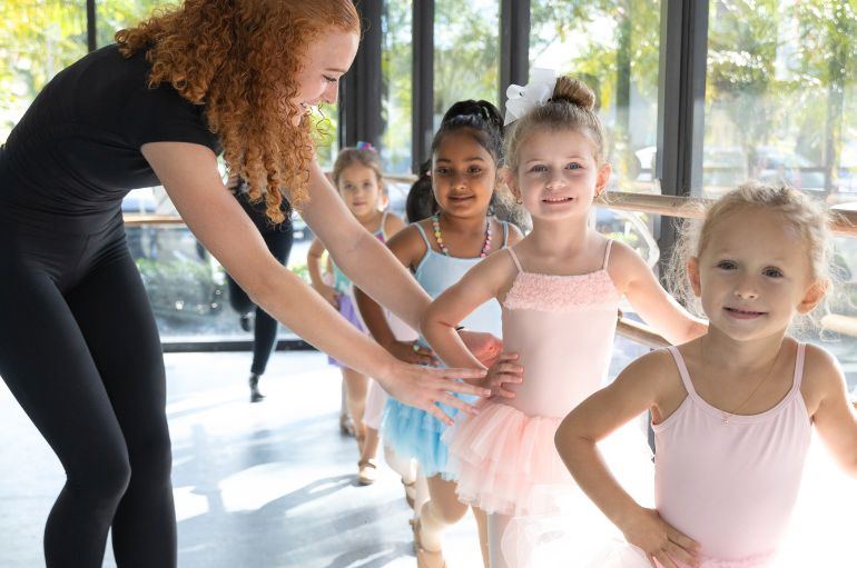 A teacher guiding young dancers at Boca Dance Studio